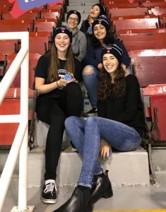 girls sitting on bleachers at hockey game