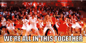 A scene from high school musical, where they're all singing and dancing in the gym. The text reads "We're all in this together".