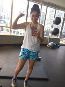Author flexing her bicep in the gym