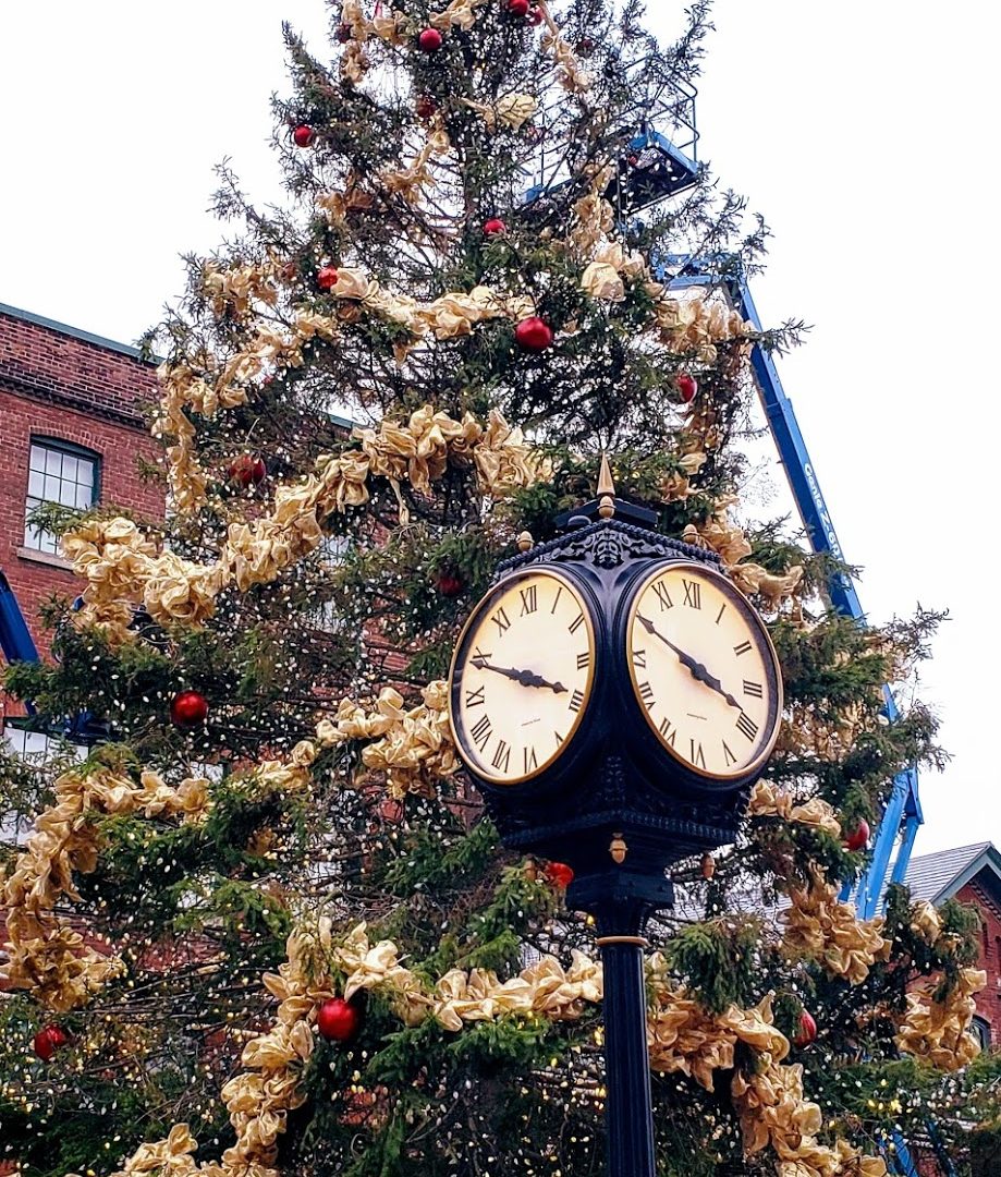 A picture of a Christmas tree and a standing clock in the Distillery District of Toronto