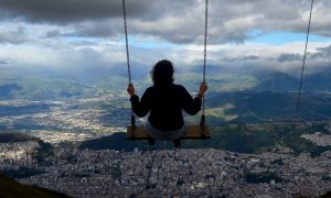 Swinging on a swing on the side of the Pichincha volcano which overlooks Quito, Ecuador