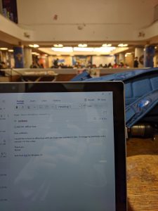 Photo of laptop with a sample email and dim lighting in background