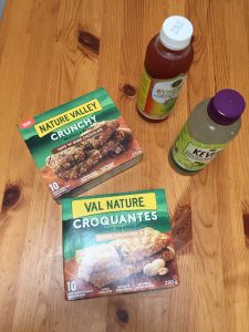 A picture of two boxes of granola bars and two bottles of kombucha 
