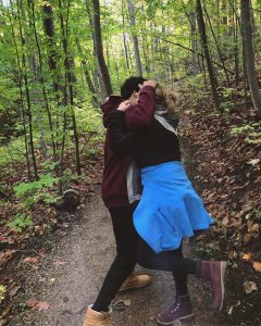 Francesca's mom playfully fighting with Francesca's younger brother in a path in the woods.