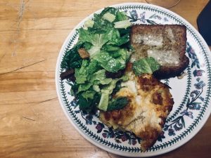 A plate of lasagna, garlic bread and caesar salad.