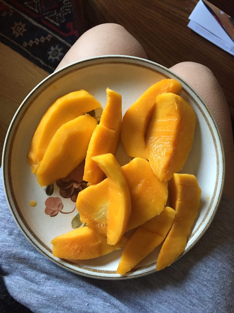 A picture of a plate of sliced mango