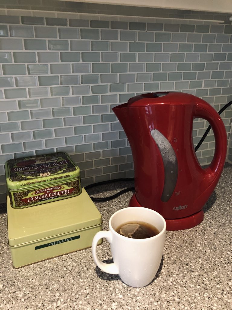 Red tea kettle and mug of tea. 