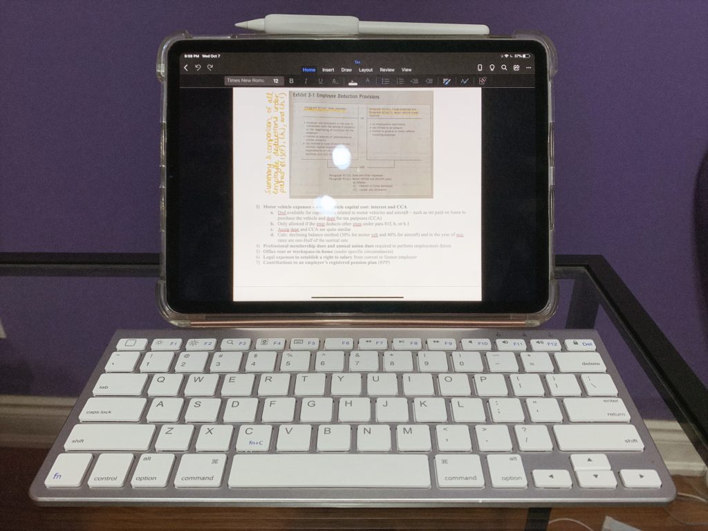 iPad Pro opened on a word document with apple pencil attached and paired with a white bluetooth keyboard 