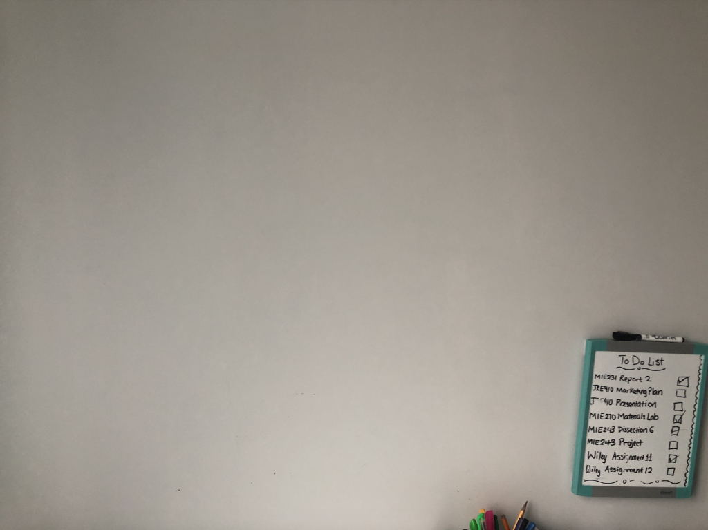 A plain white wall with a white board