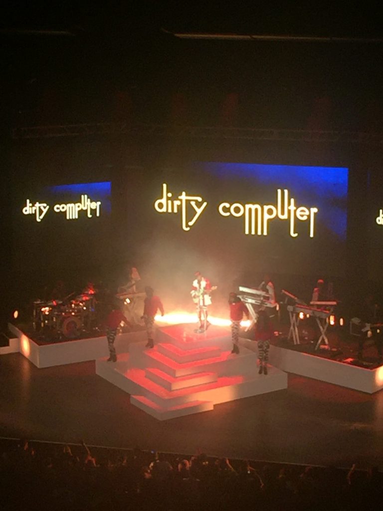 A picture of a stage at a concert with the words "dirty computer" behind it