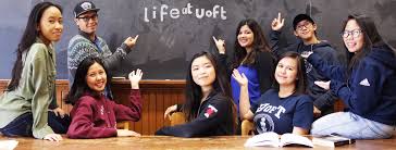 Nine students sitting around the blackboard, reading "LifeatUofT"