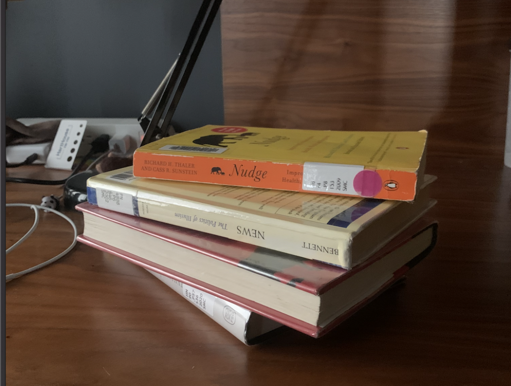 a stack of library books on a desk