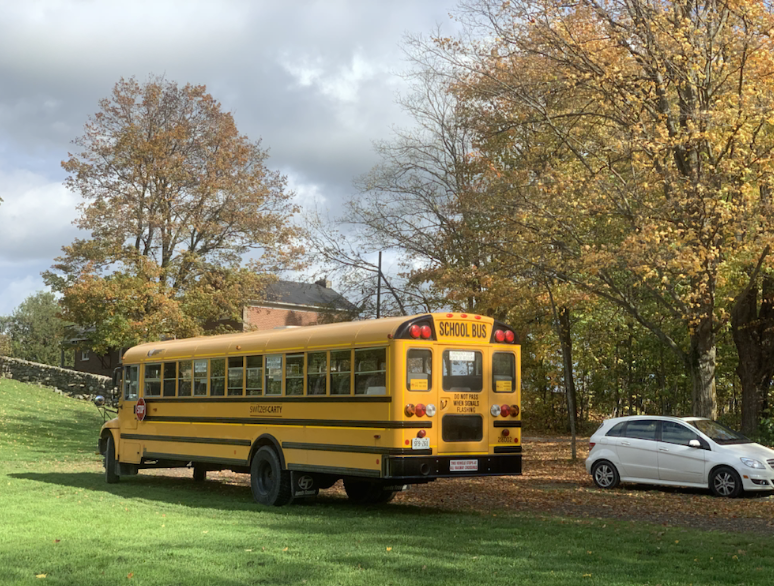 a yellow school bus waiting by the farm