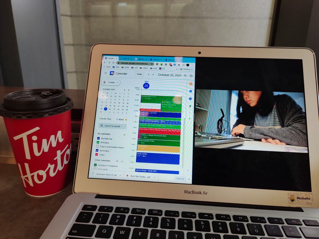 A laptop screen showing a calendar on the left and a person studying in the right. A Tim Hortons coffee is placed next to the laptop