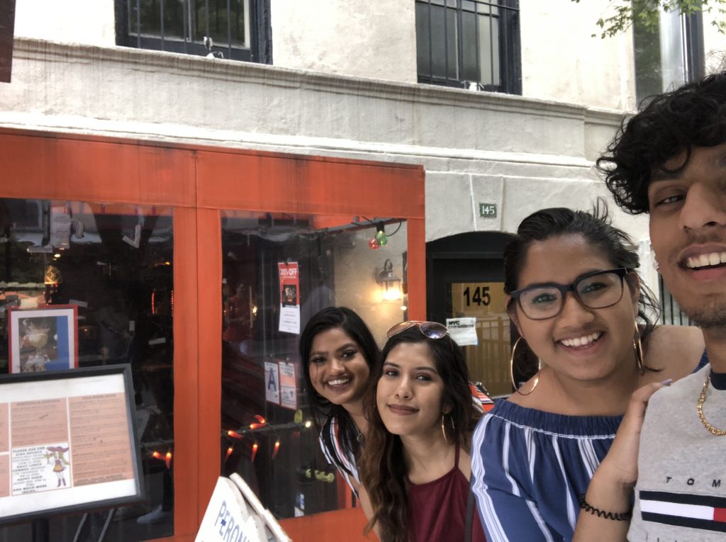 4 cousins taking a selfie in front of a restaurant in New York City 