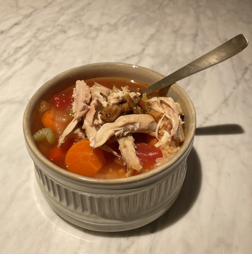 a bowl of chicken, carrot, celery, and tomato soup