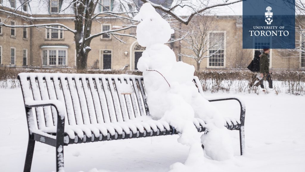 A snowman sitting on a bench at the University of Toronto on a winter day