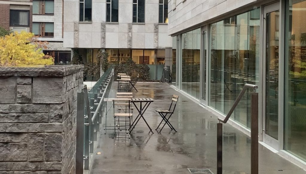 Building patio with wooden chairs and tables on a rainy day