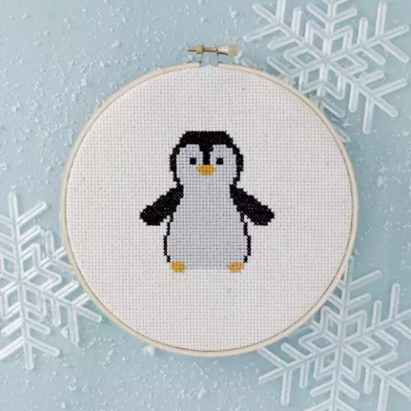 Cross stitch art with a little, adorable penguin design.