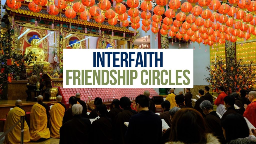 People sitting and gathered inside a temple with red lanterns hanging above. [TEXT: Interfaith Friendship Circles]