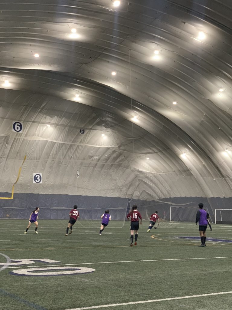 Soccer players on an indoor Varsity field