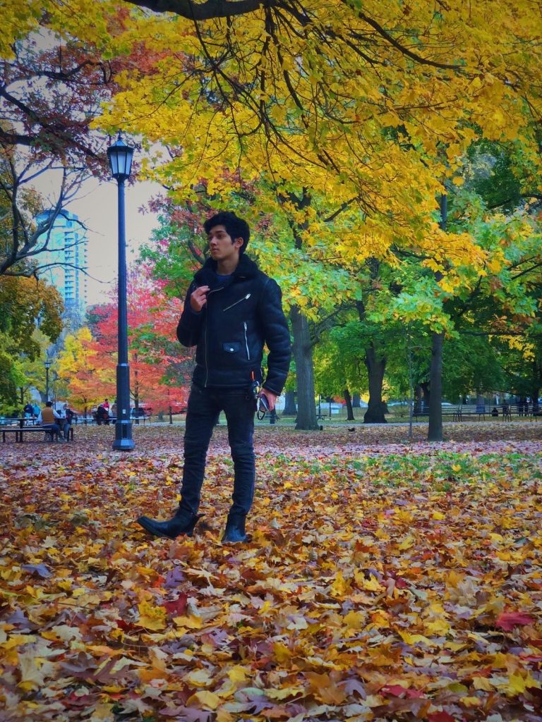 Photo of Storyteller Razzak standing outside with leaves on the ground
