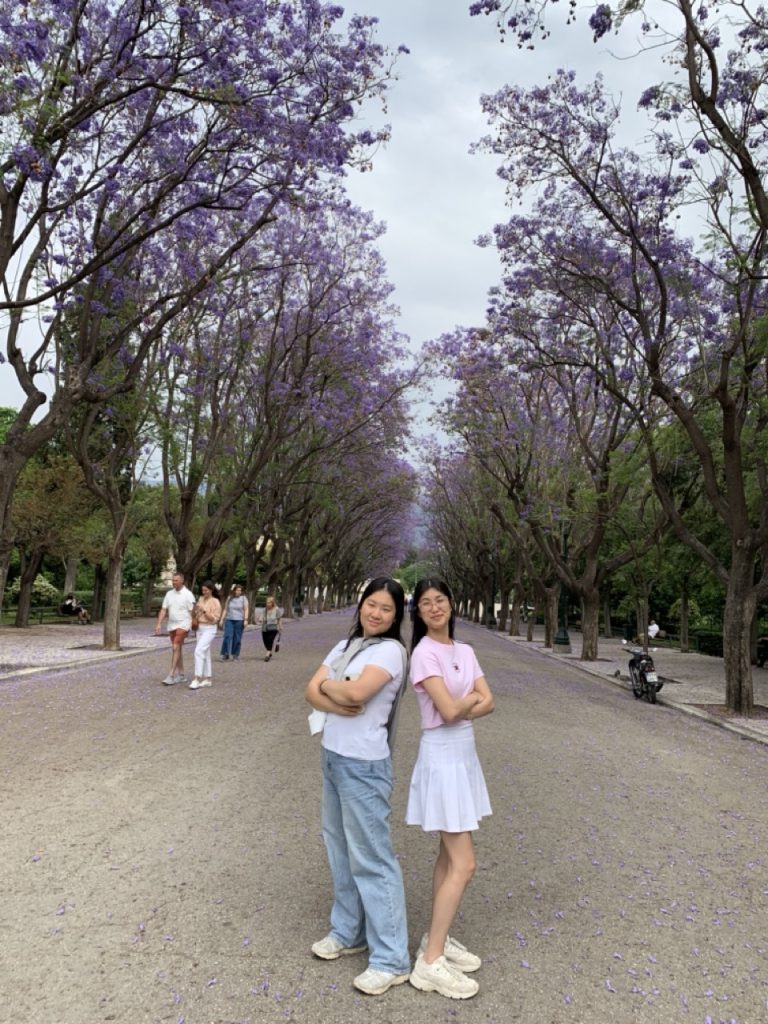 Photo of two people standing with trees on either side
