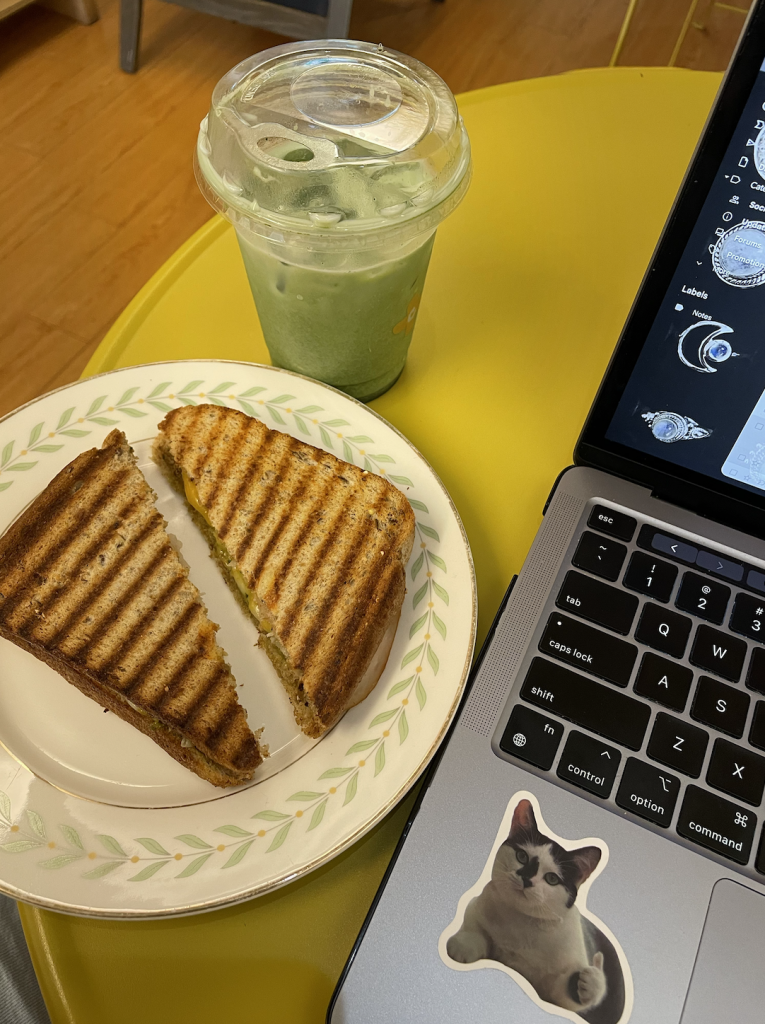 Photo of a green smoothie, grilled cheese sandwich and a laptop