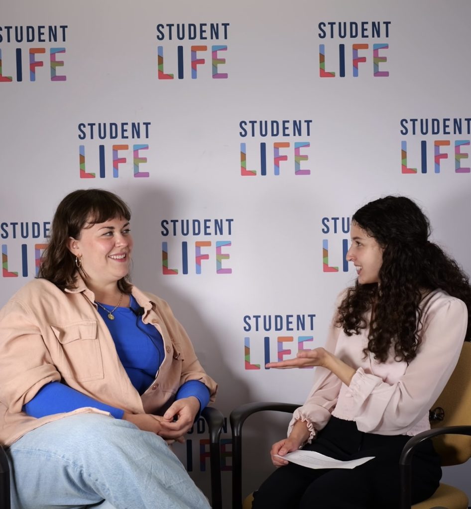 Sammi Herlich and Britta Johnson in front of Student Life back drop.