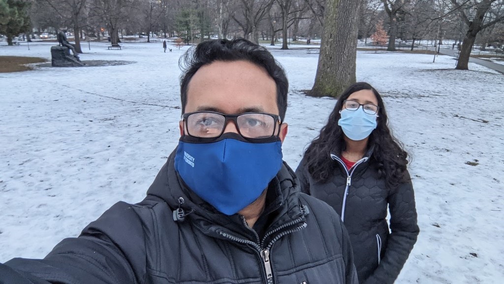 Shamim and his family in a snowy park, with masks on but it looks like they're smiling!