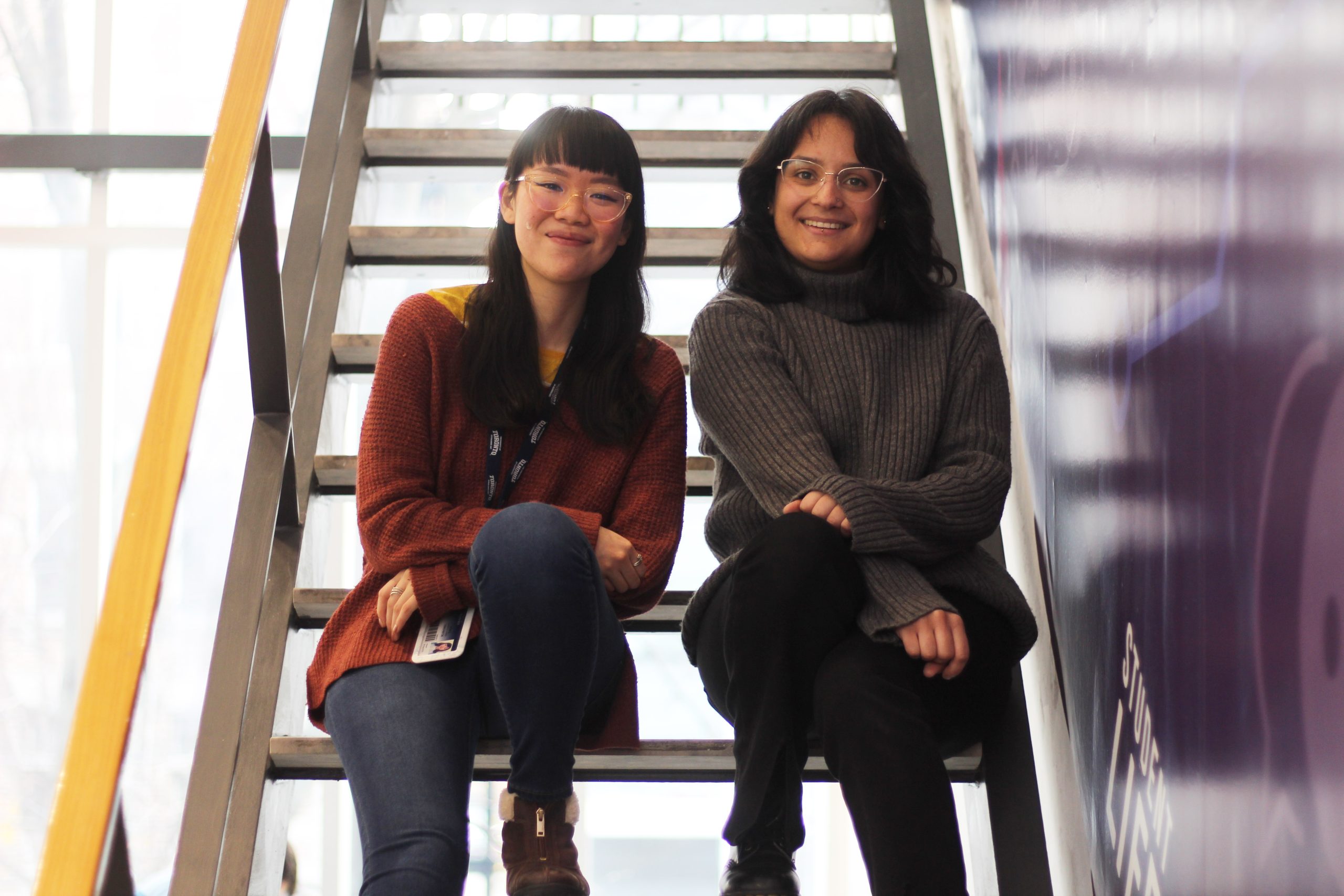 Two people sitting on a staircase and smiling