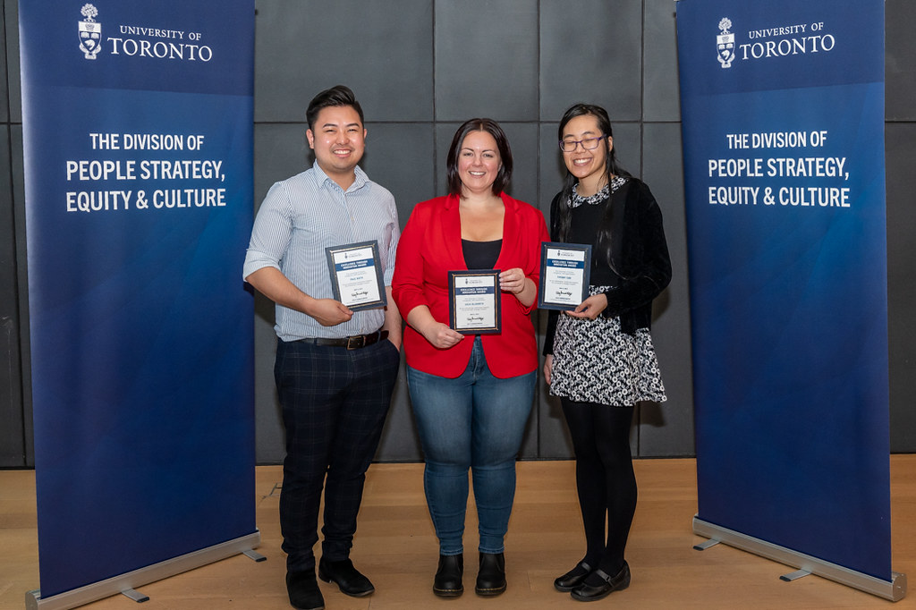 Three people holding award for Excellence in Innovation