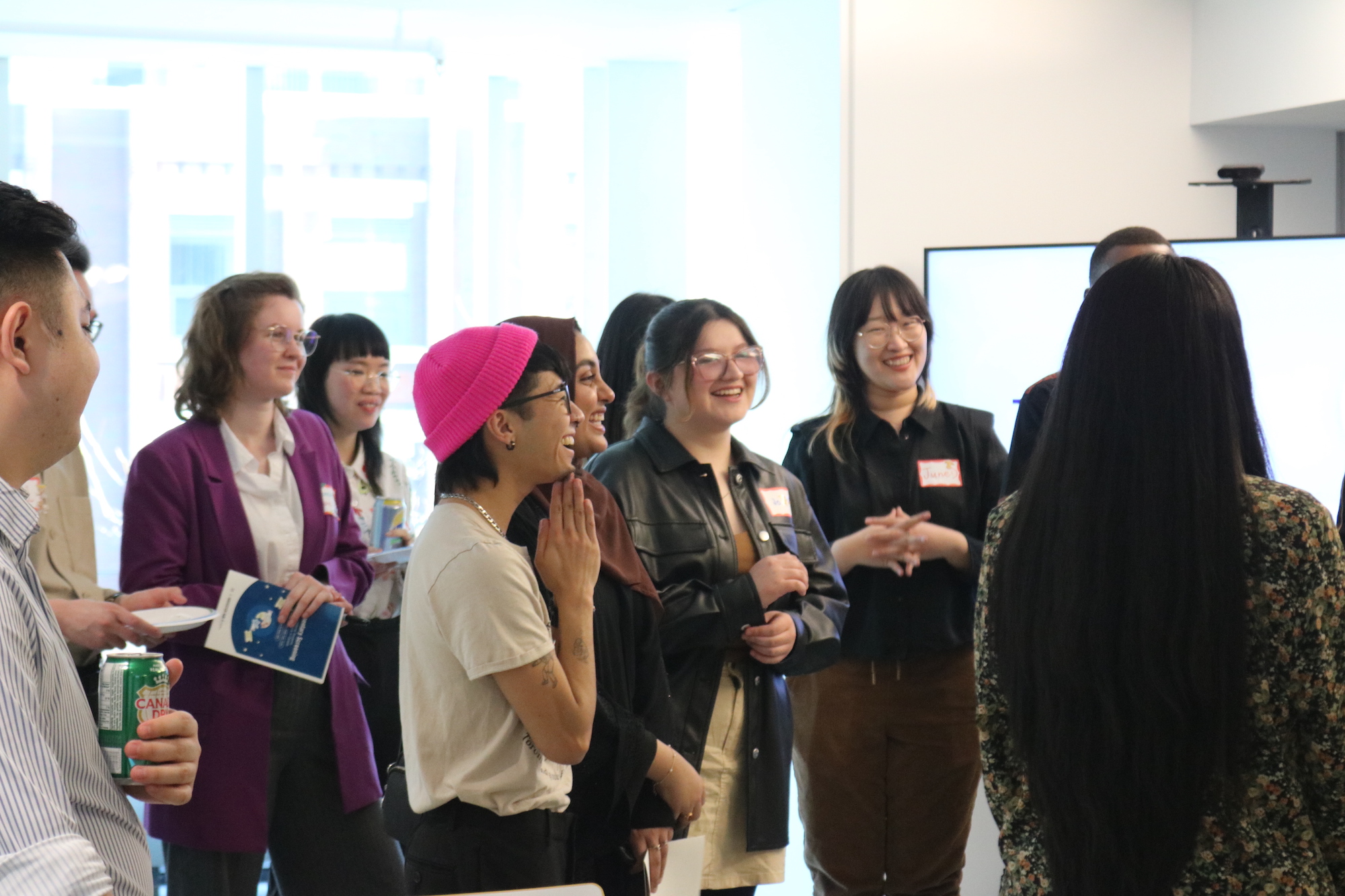 Crowd of people smiling and facing the front of the room