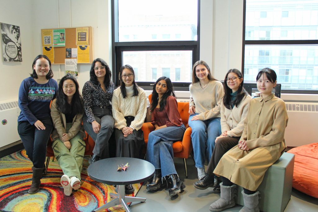 Group of people sitting down and smiling for a team photo