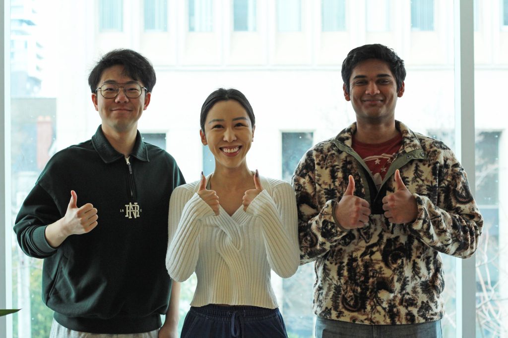 Three people smiling and holding up thumbs-up