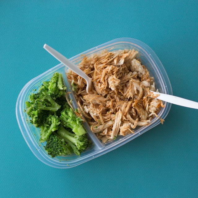 Two part tupperwear with steamed broccoli and pulled chicken.