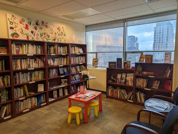 A room with shelves of books and seating for adults and children.