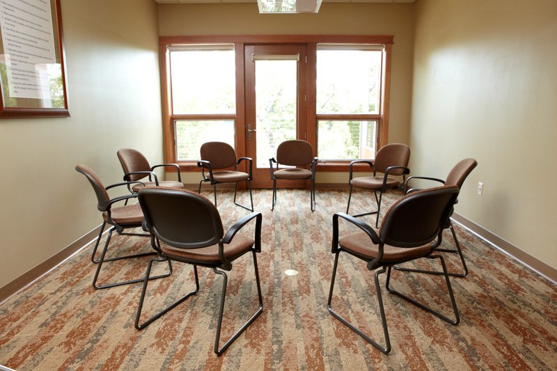 Group of empty chairs arranged in a circle, facing each other