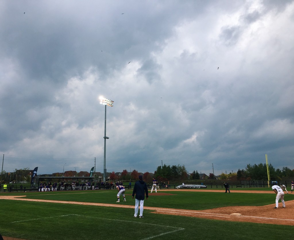 A baseball game takes place under a cloudy sky.