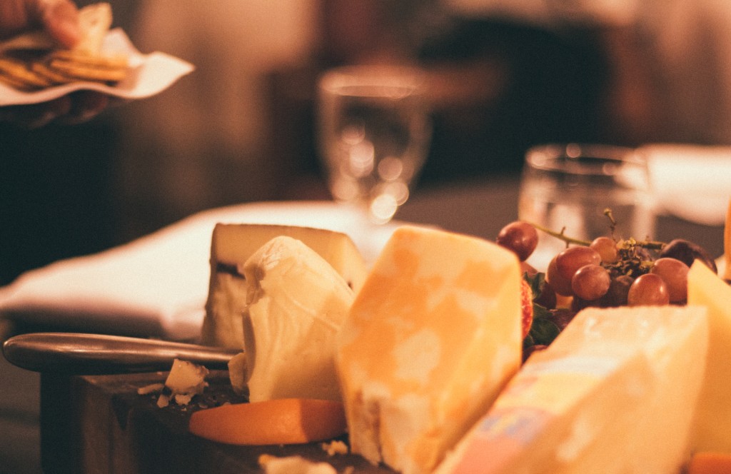 A photo of several blocks of different kinds of cheese on a platter.