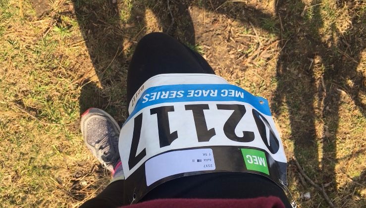 A runner displays a numbered bib on her leg.