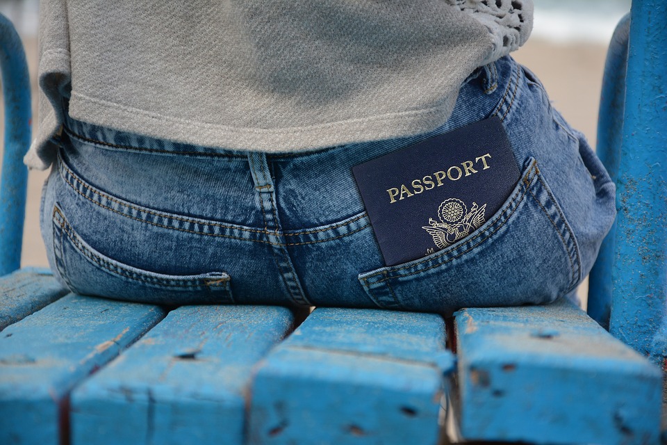 Photo of someone sitting with passport sticking out of pants pocket