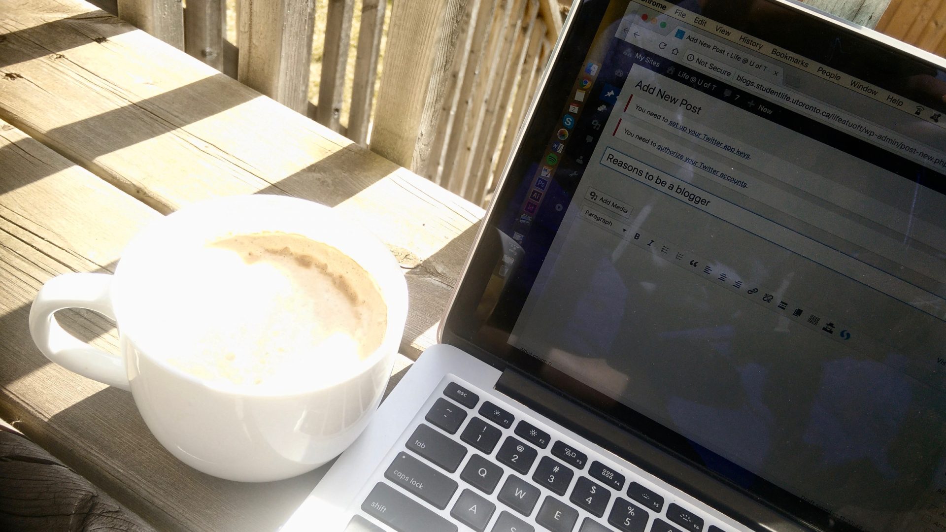 picture of my laptop and big cup of coffee on my backyard deck
