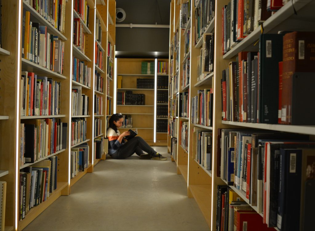 Girl reading book in library