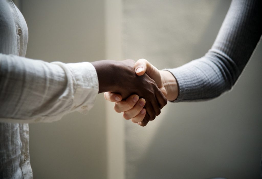 Stock photo of two people shaking hands. Caption: I really, really want an internship