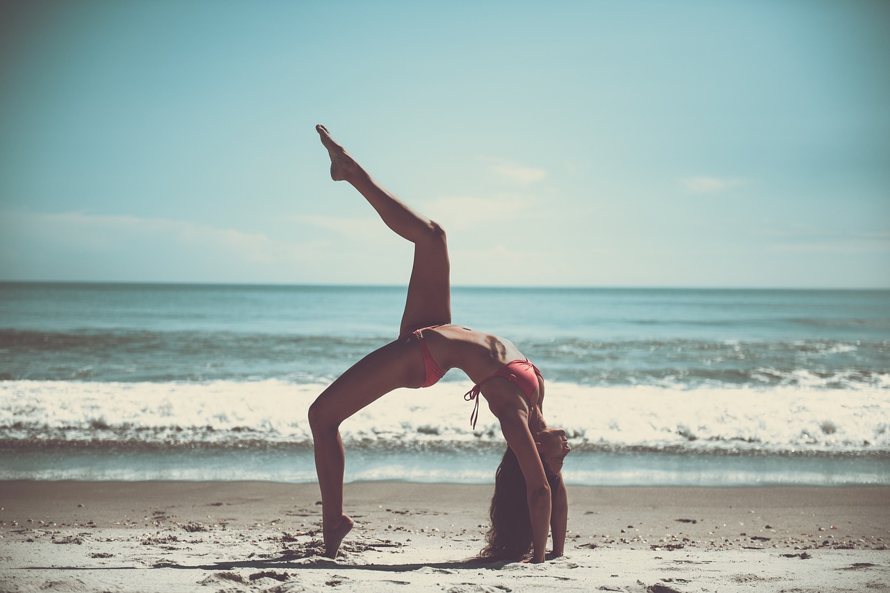 Image of woman doing a yoga pose on the beach