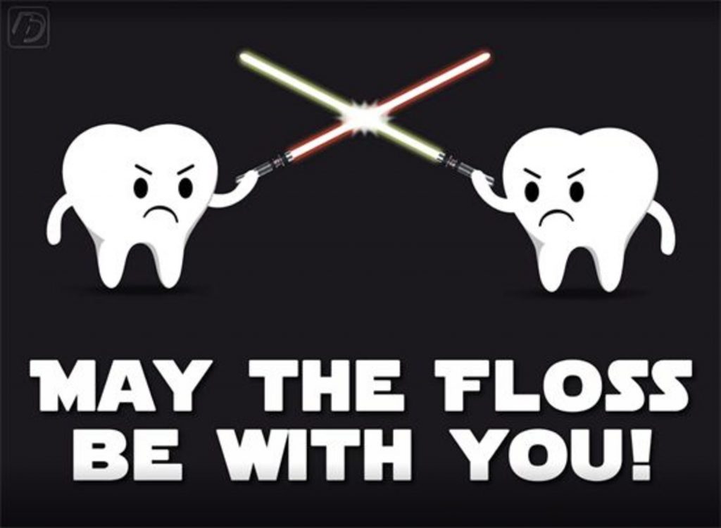 Two teeth fighting with light sabers, captioned "May the floss be with you!"