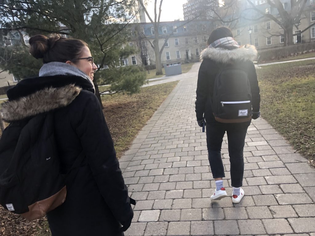 Two girls walking through a quad in the University of Toronto