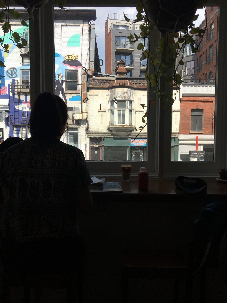 Photo of silhouette against window of city