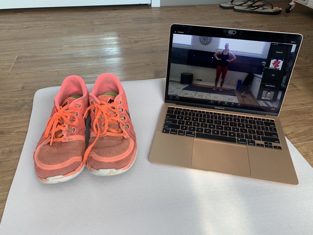 shoes on a yoga mat besides laptop